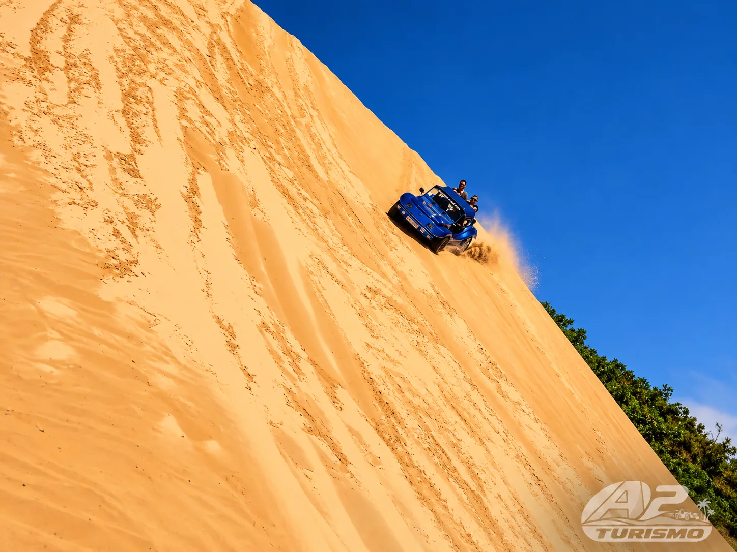 Buggy azul em uma descida íngreme de duna