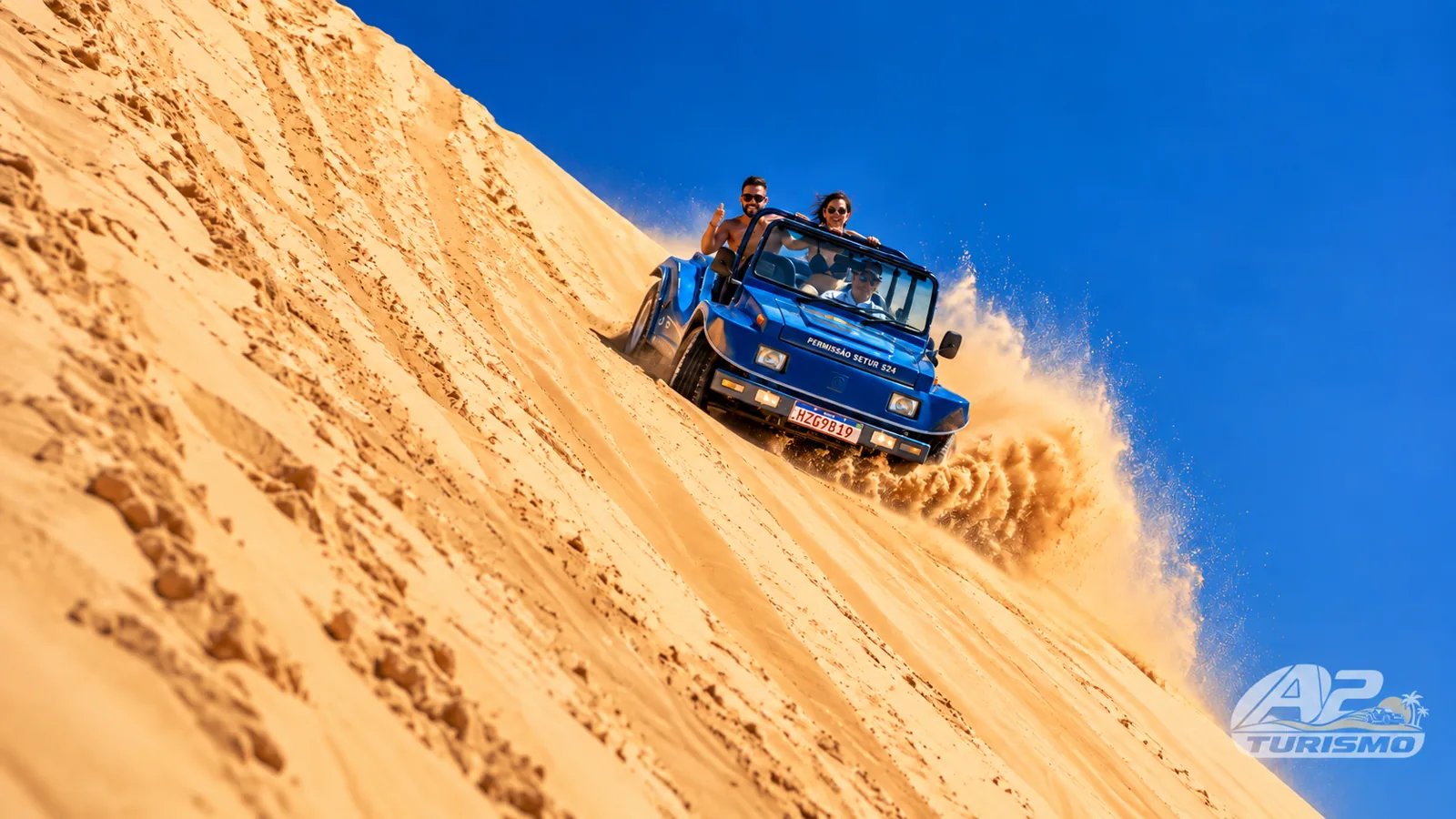 Buggy azul descendo uma duna de areia